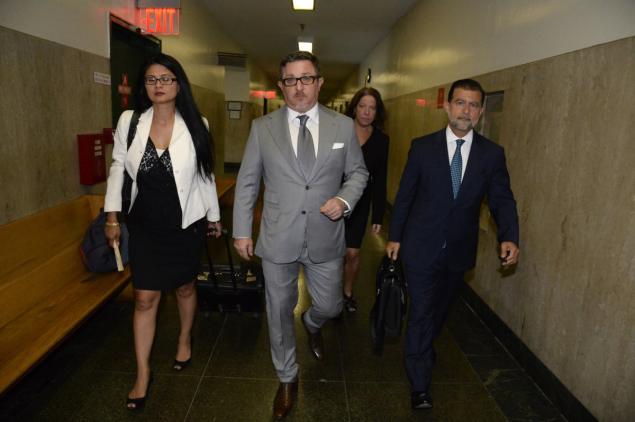 Gene Freidman walking with his attorneys in a courthouse hallway