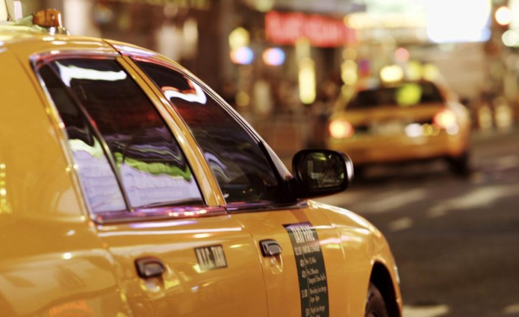 Close-up of a yellow taxi on a city street at night