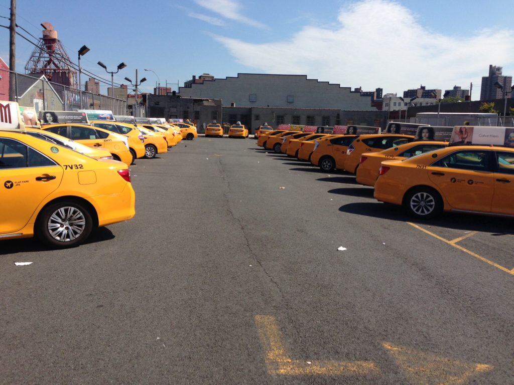 Rows of yellow cabs parked in a Queens lot