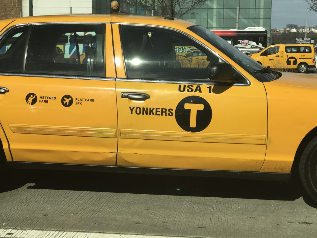 Side of a Yonkers-licensed taxi with NYC T logo markings