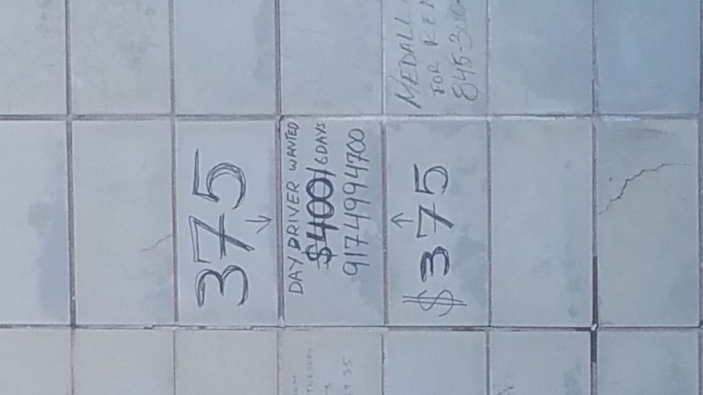 Handwritten taxi lease prices of $375 and $400 chalked on a sidewalk