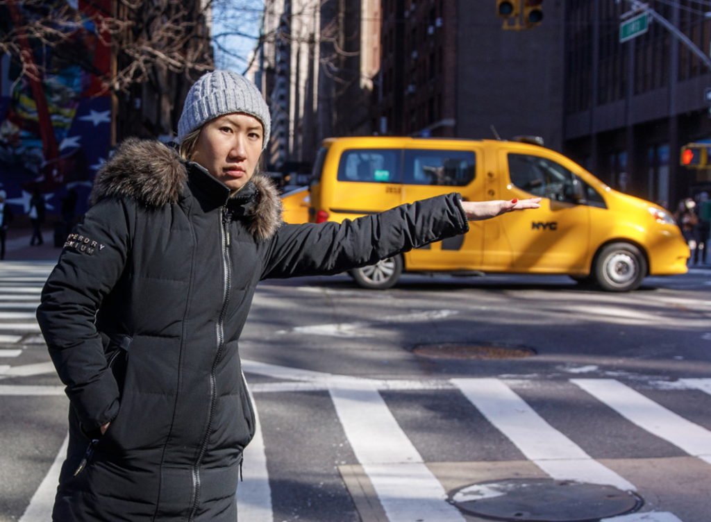 Woman hailing a yellow cab on a New York City street