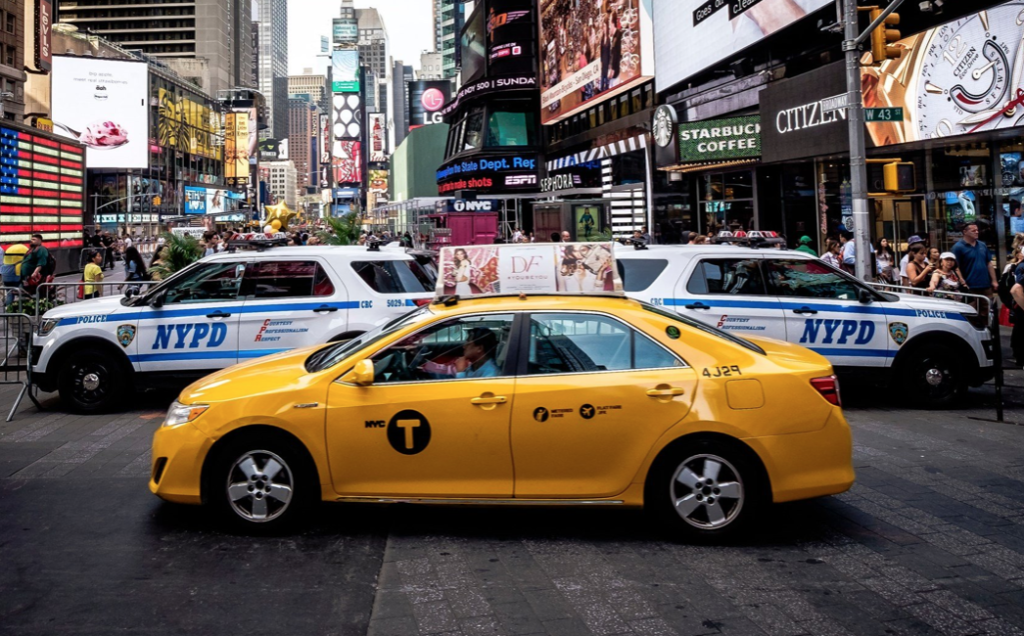 Yellow NYC taxi and NYPD cars in Times Square