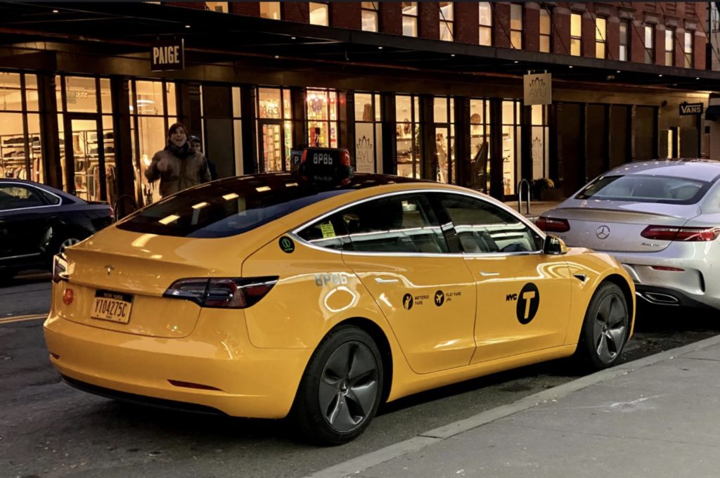 Tesla Model 3 yellow cab parked on a New York City street